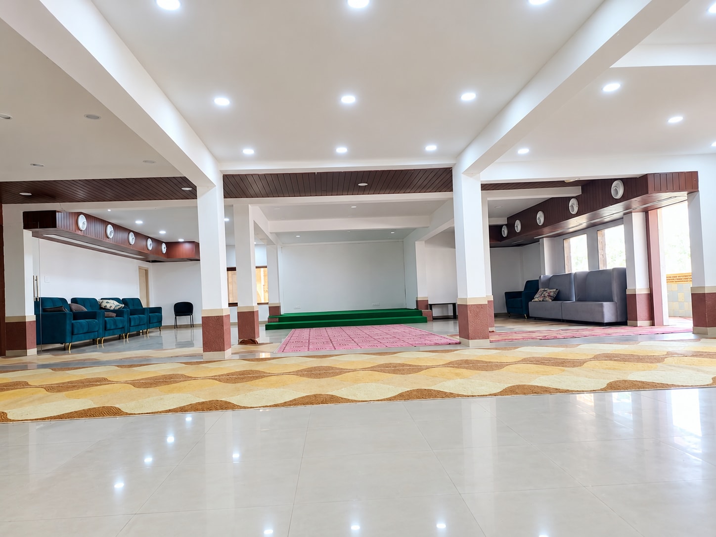 banquet hall seen from the entrance, lounge seating and stage in the distance