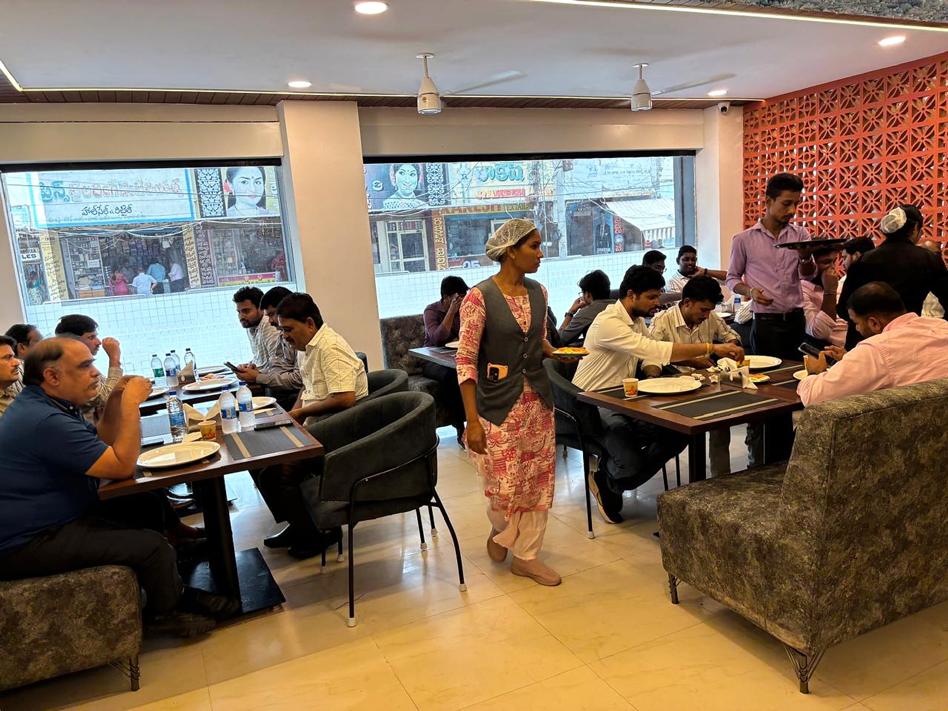 restaurant dining area, guests seated, terracotta jali wall