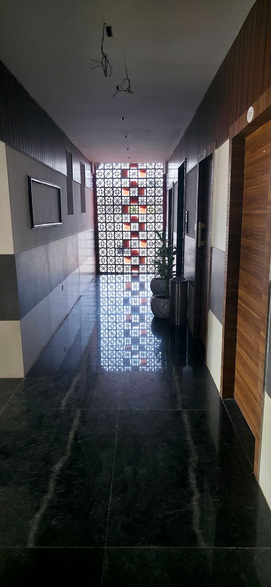 corridor with decorative geometric screen and room doors