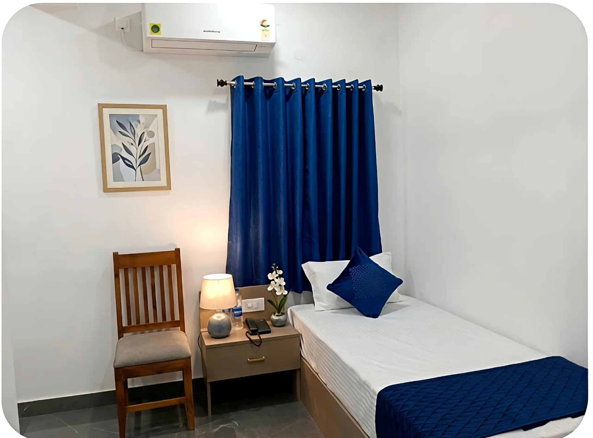 single/twin bed, blue curtain and pillow accents, small room