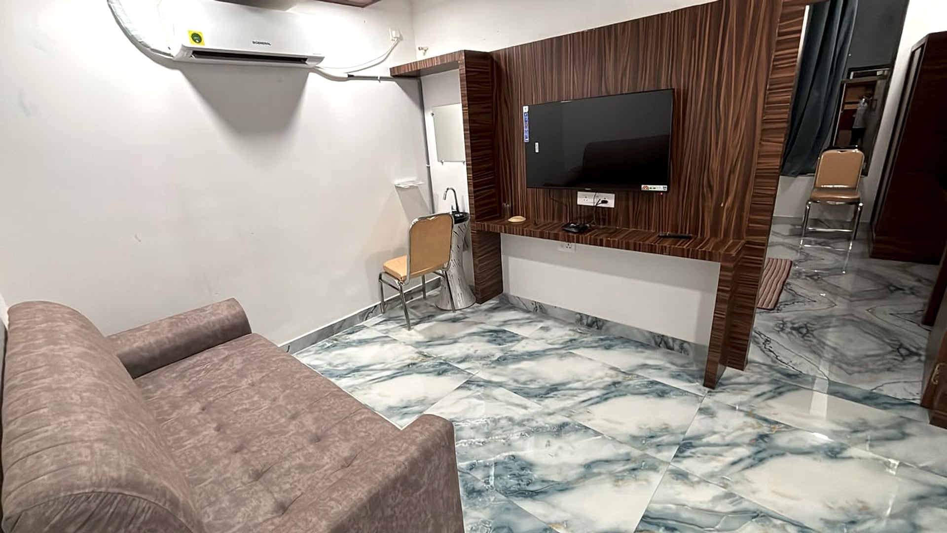 Suite Room living area, wood-panelled TV wall, sofa